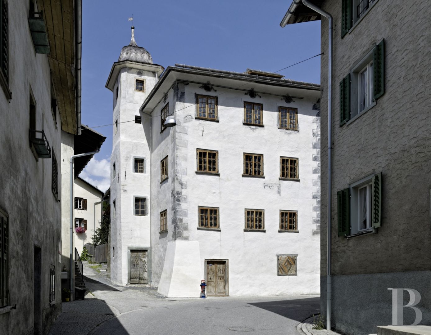 In Switzerland, in the canton of Graubünden, a baroque house and its tower in the heart of a mountain village - photo  n°1