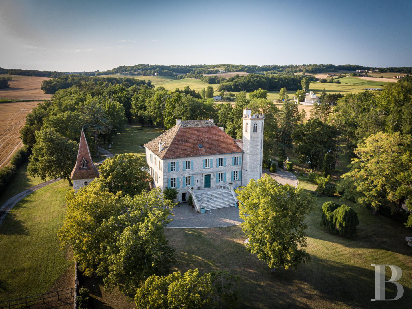 An 18th century chateau surrounded by trees and hills in the Lot valley - photo  n°1