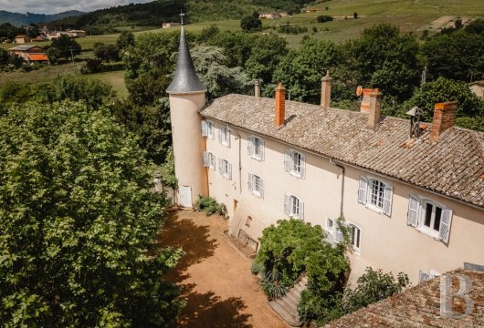 rhones-alps - Dans le Beaujolais, à proximité du mont Brouilly, un château avec sa tour à toiture en poivrière et ses anciennes dépendances viticoles